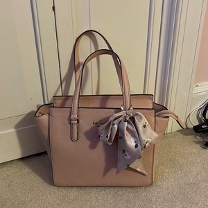 Pink Kate Spade bag with a bow and detachable strap